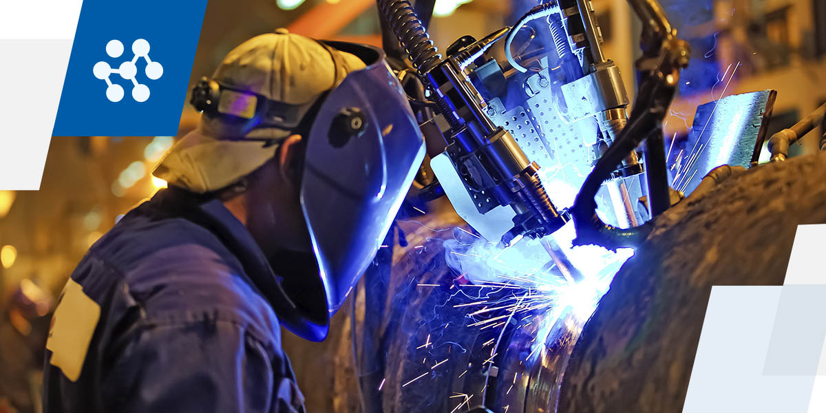 a man wearing a welding mask is welding a piece of metal