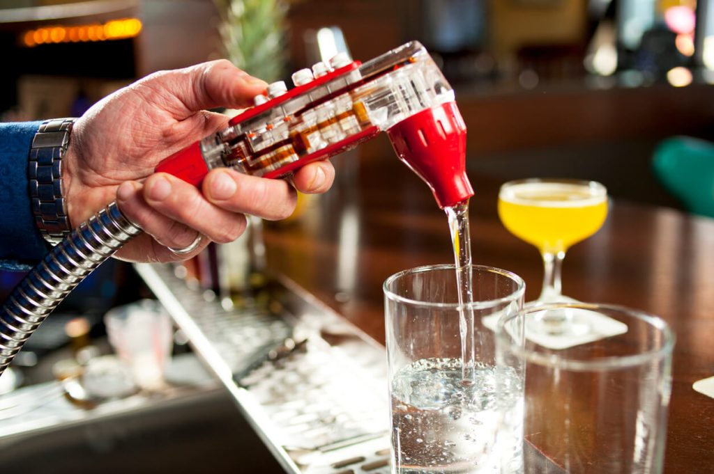 a bartender is pouring a drink into a glass