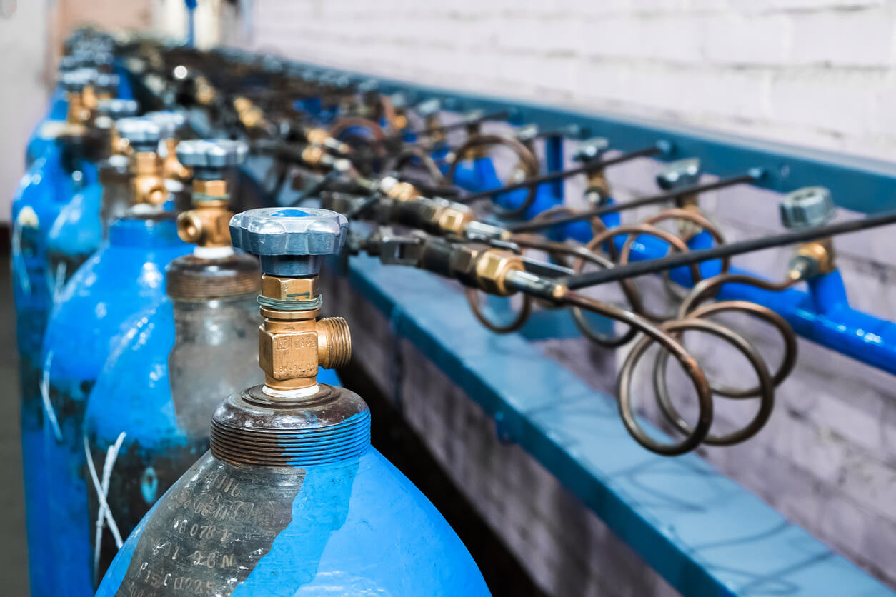 a row of blue gas cylinders with the letter x on them
