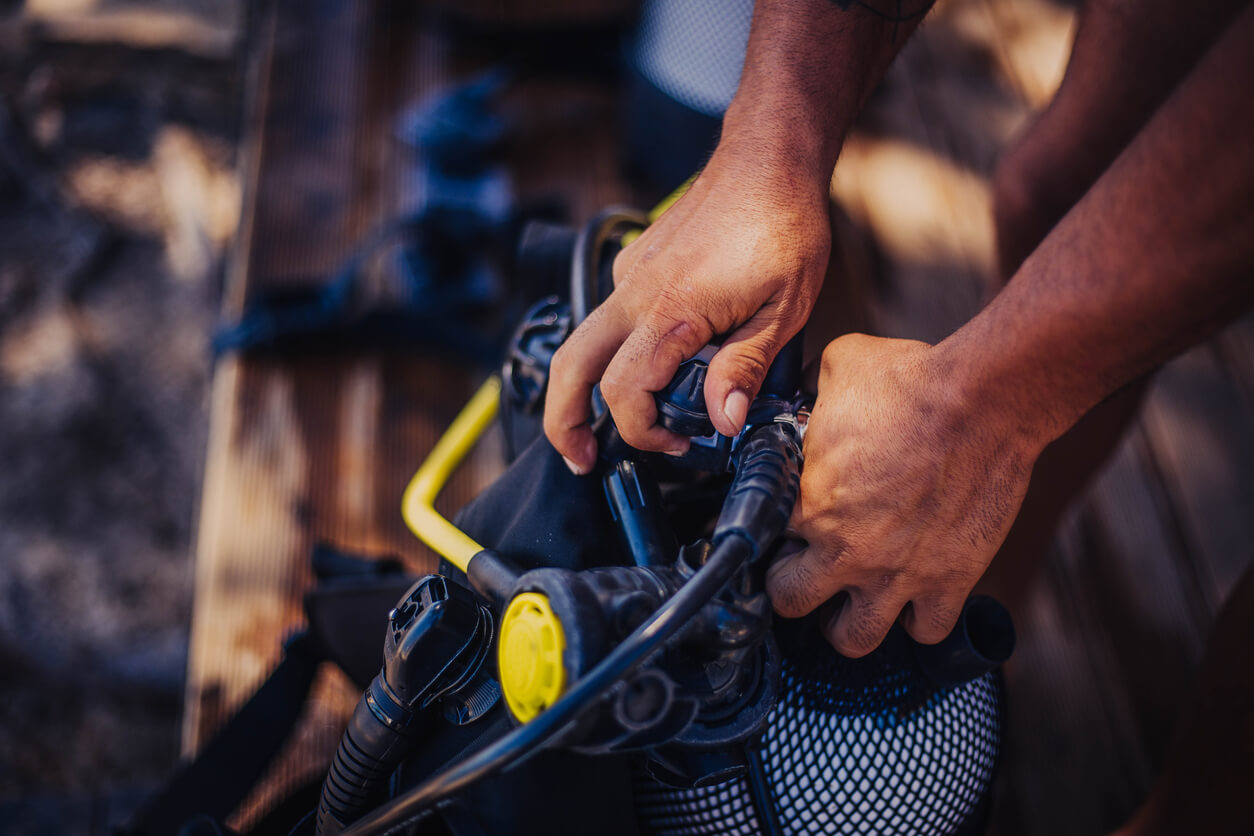 a person is adjusting a scuba gear with a yellow button that says ' scuba ' on it