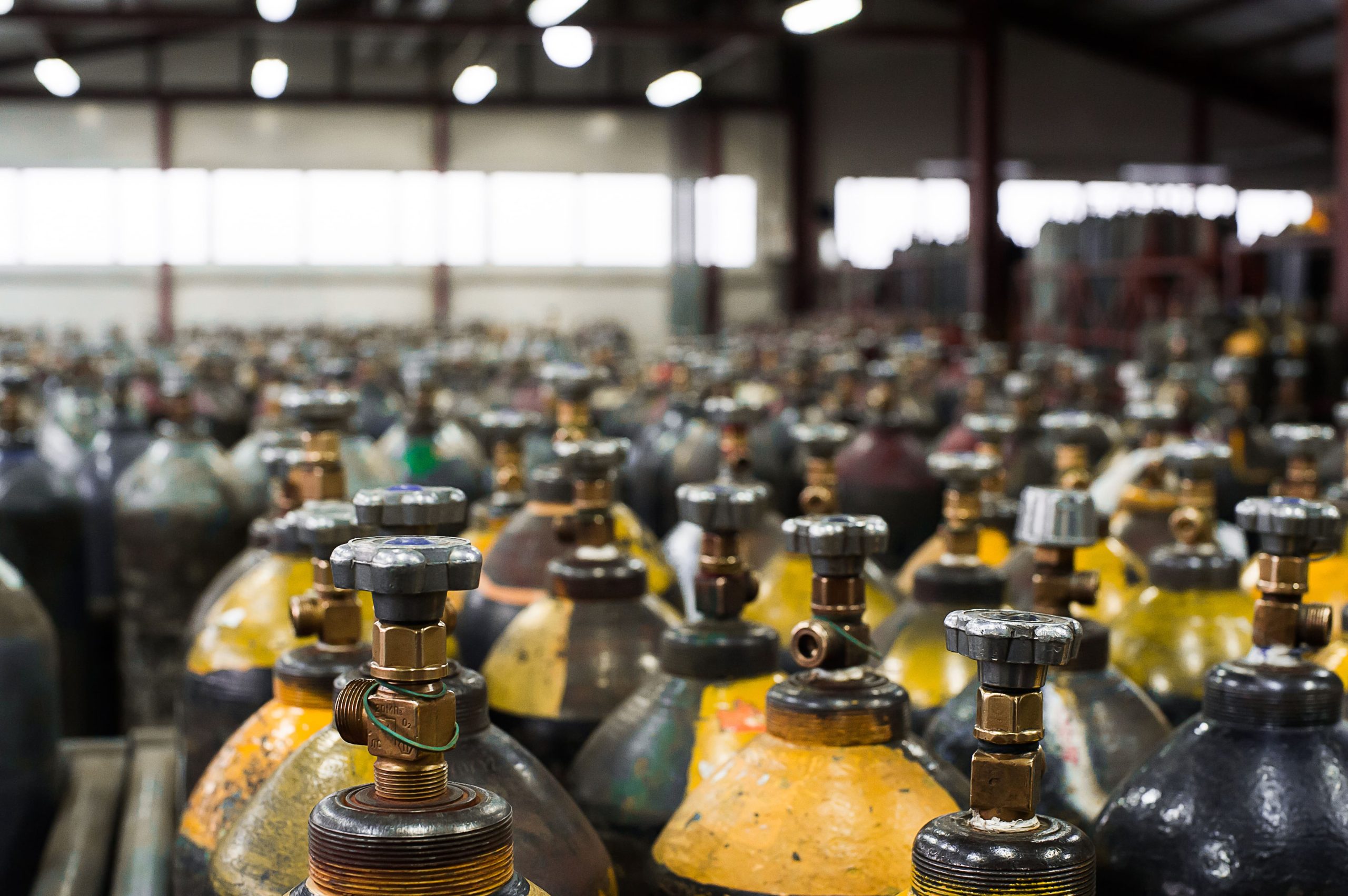 a bunch of gas cylinders are lined up in a warehouse
