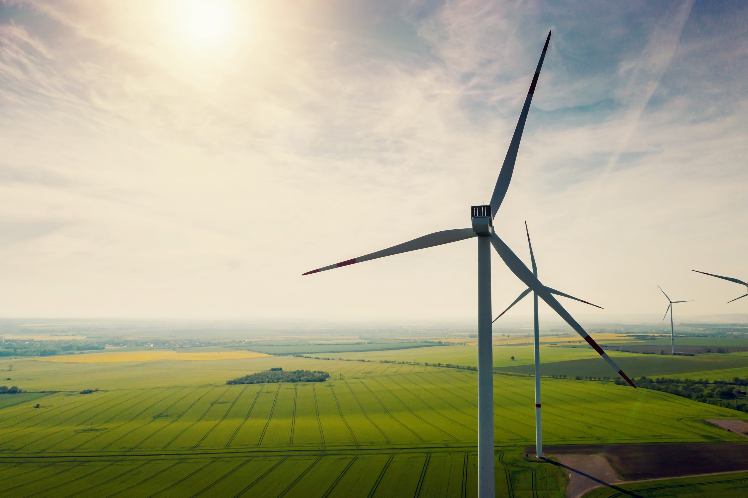 an aerial view of wind turbines in a green field