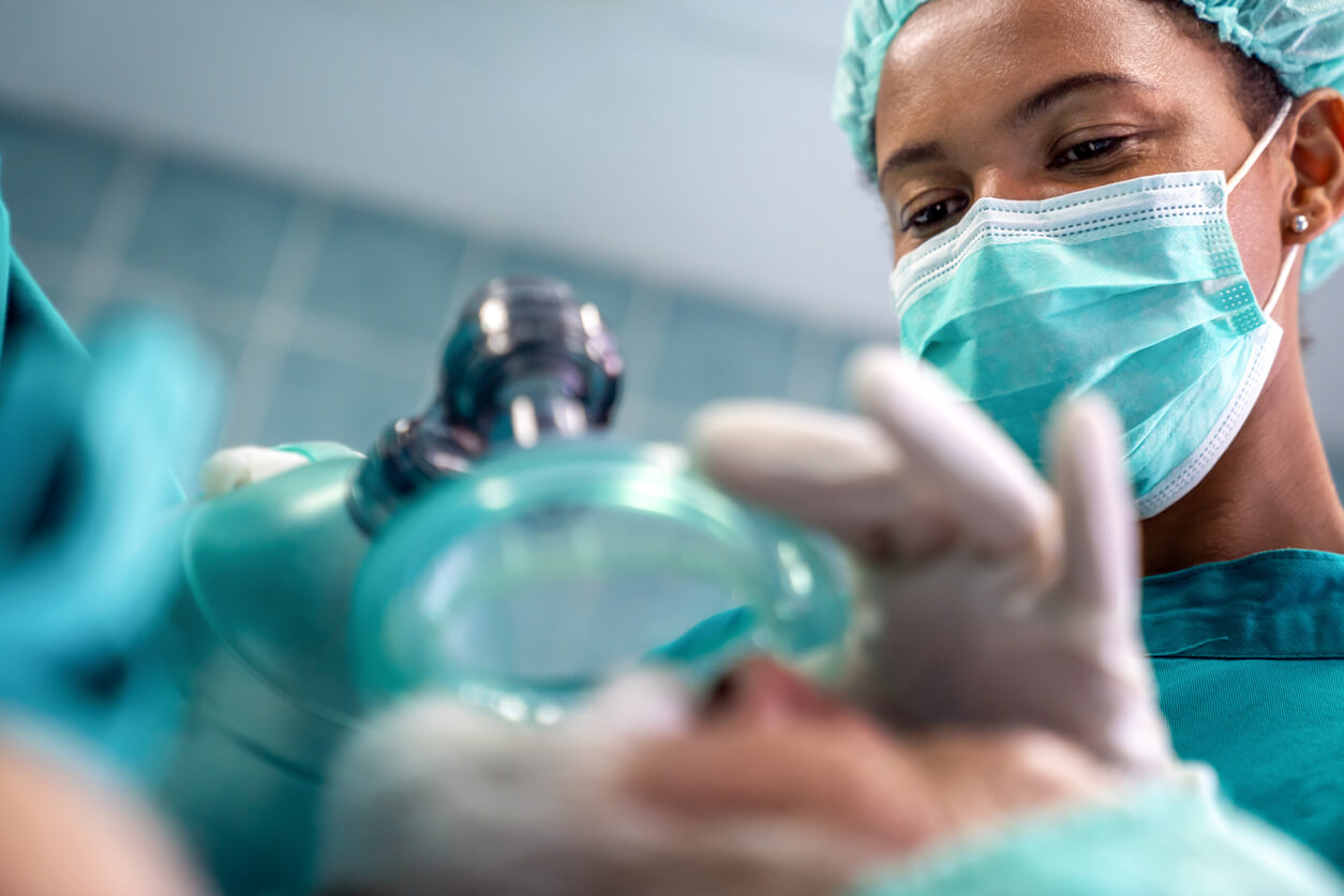a female surgeon is putting an oxygen mask on a patient