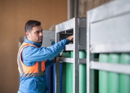 a man in a blue jacket and orange vest is working on a machine