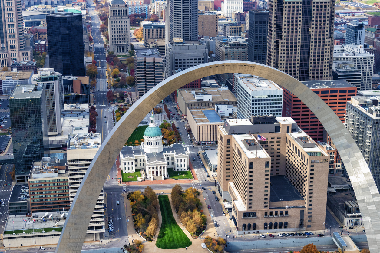 an aerial view of St. Louis with the gateway arch in the foreground
