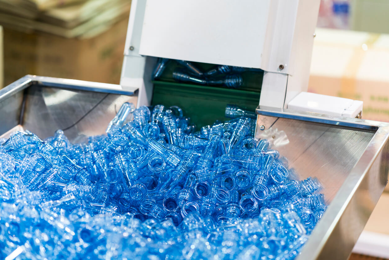 a conveyor belt filled with blue plastic bottles