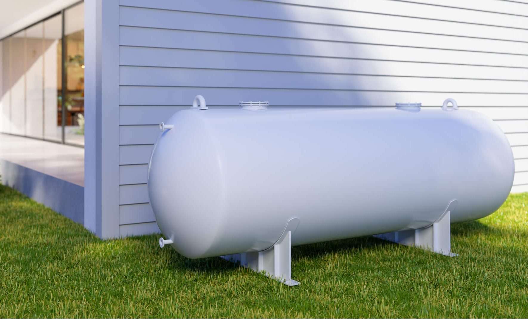 a large white propane tank sits in the grass in front of a house