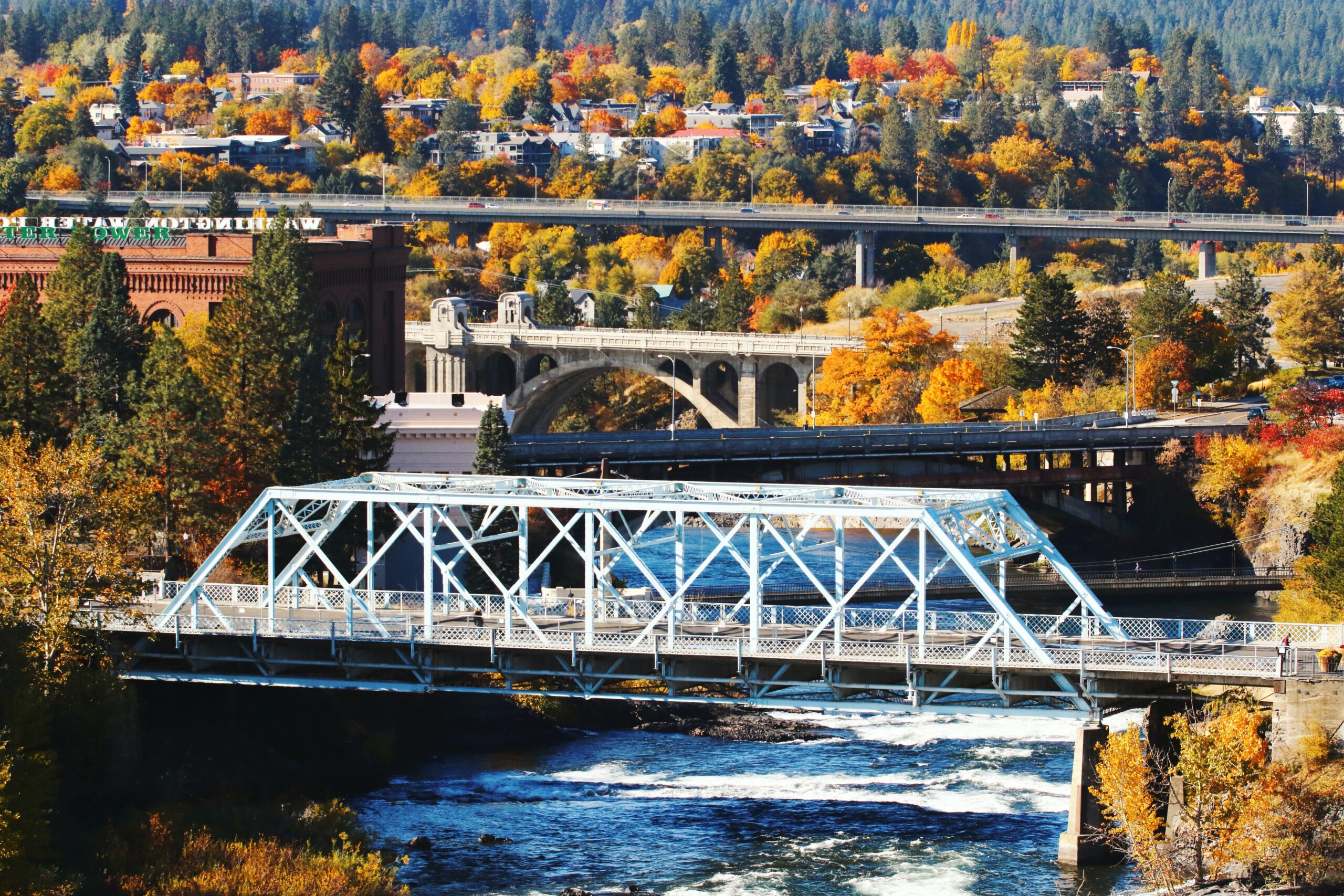 a bridge over a river with buildings in the background