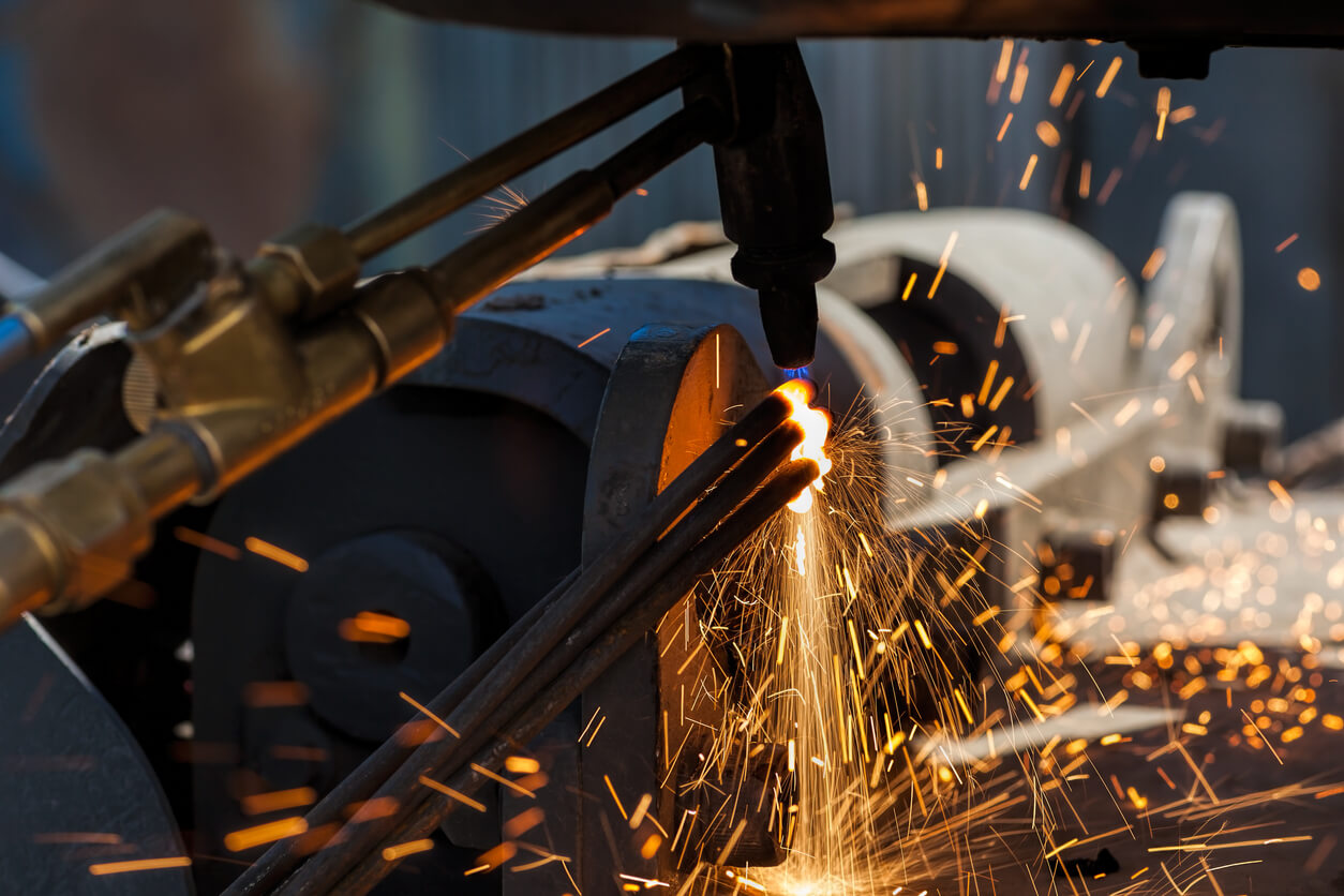 a machine is cutting a piece of metal with sparks coming out of it