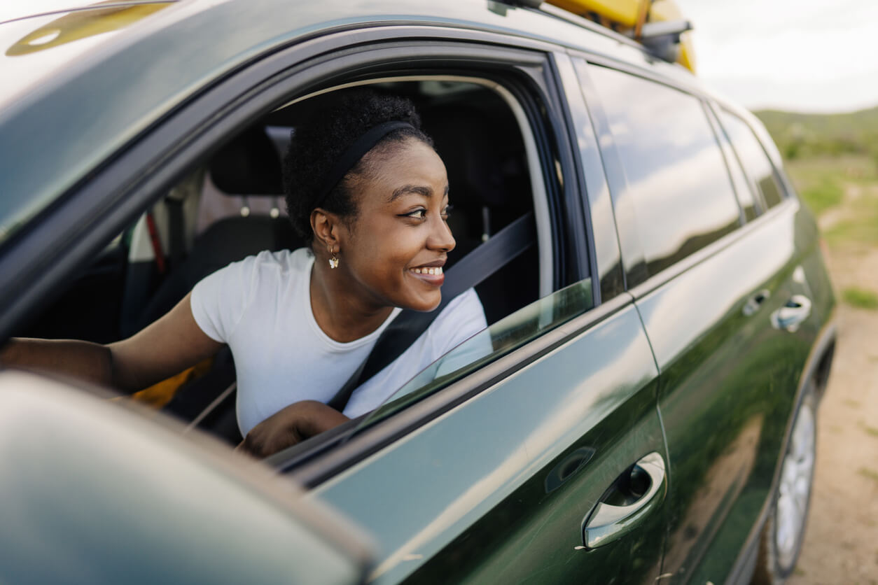a woman is smiling while looking out the window of a car